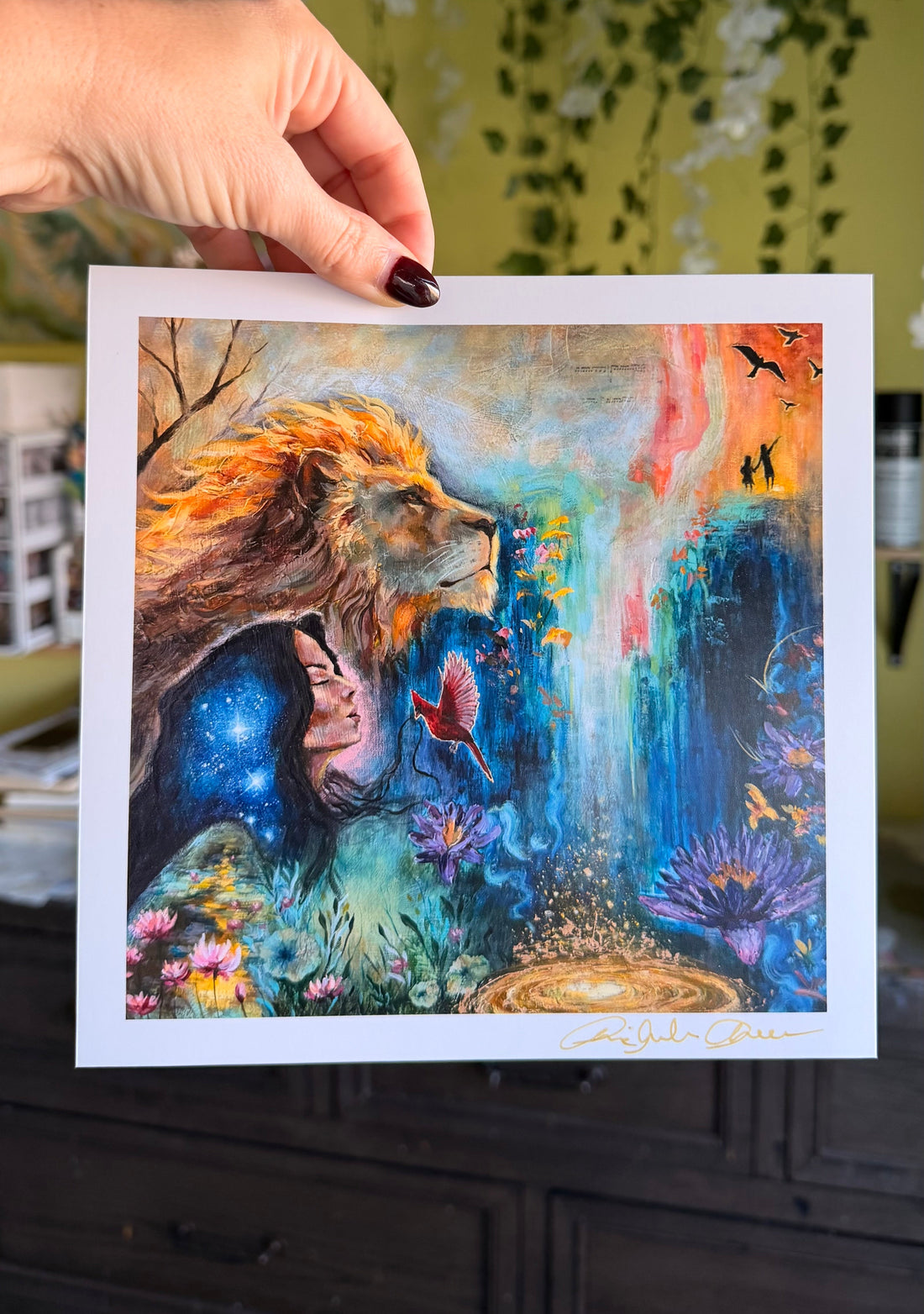 Colorful artwork of a lion with fantasy elements held by a hand against a blurred background.