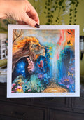 Colorful artwork of a lion with fantasy elements held by a hand against a blurred background.