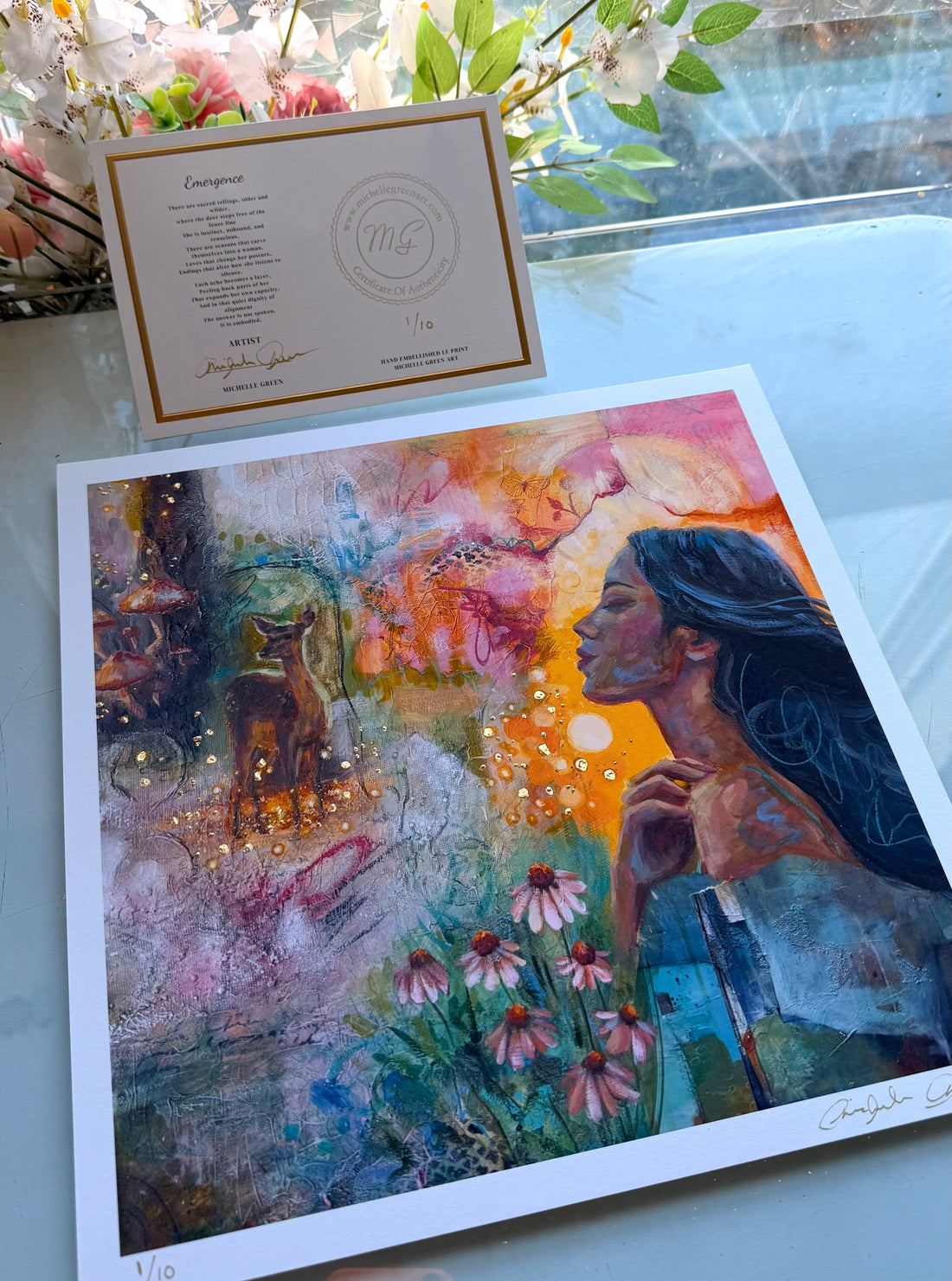 Artistic print of a woman and dog in a colorful garden held by a hand.