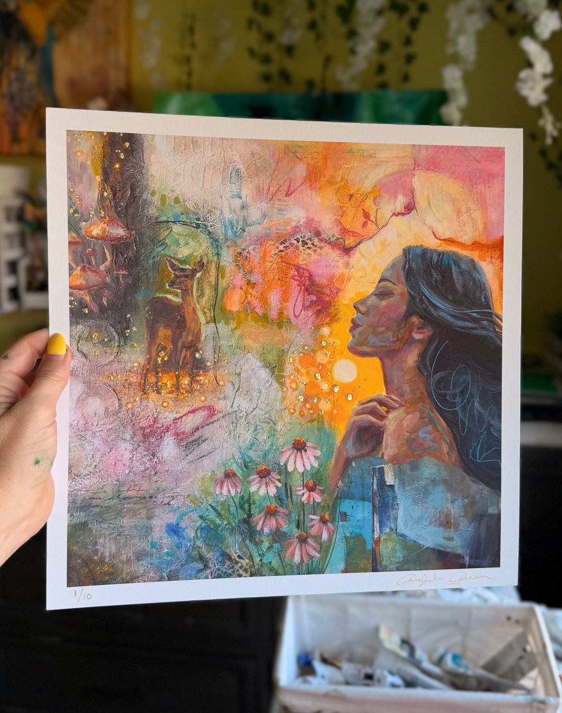 Artistic print of a woman and dog in a colorful garden held by a hand.