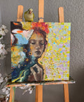 Colorful mosaic art on a wooden easel with a bird perched on top against a gray wall.
