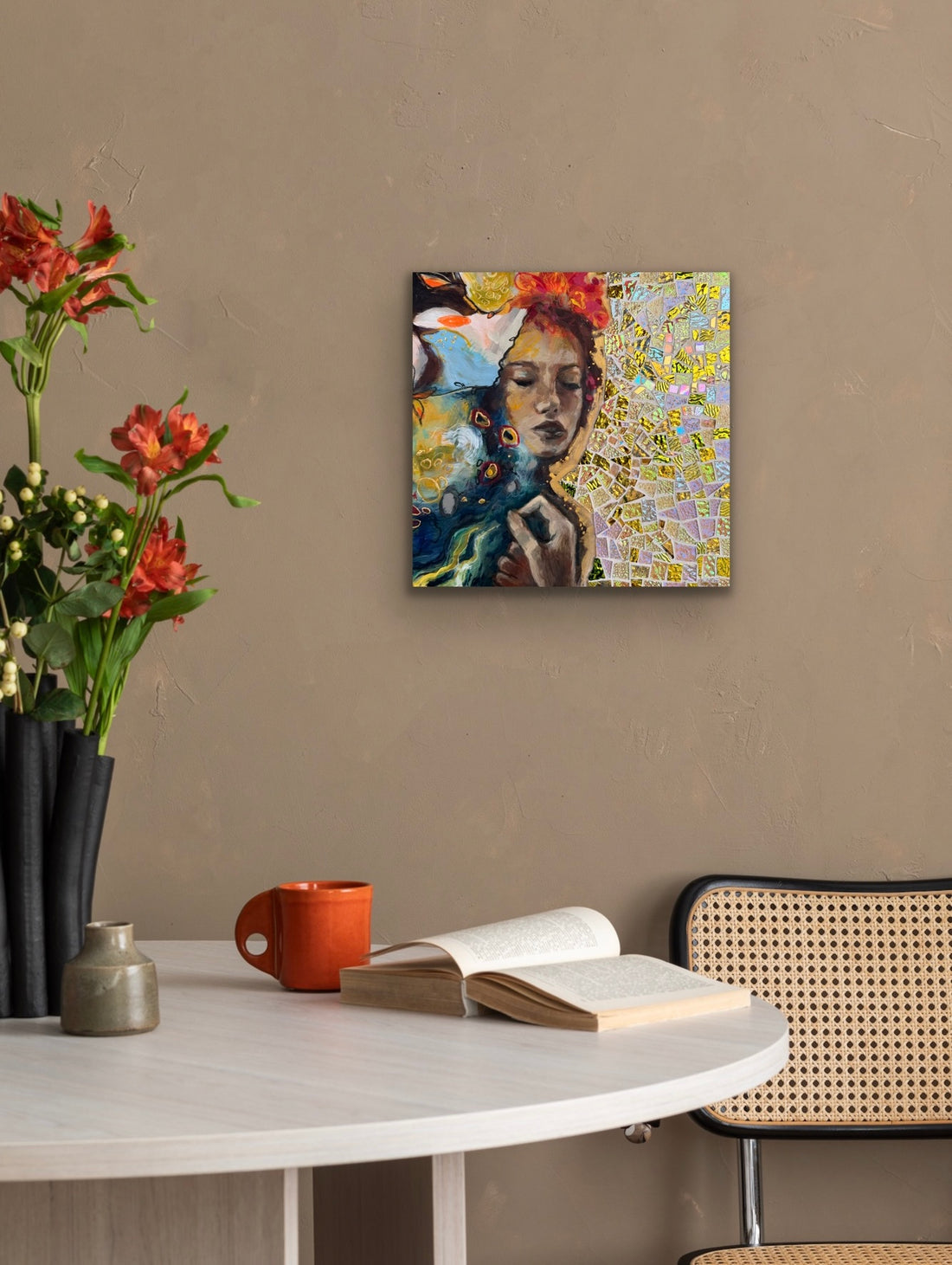 Colorful abstract painting on a wall above a table with a book and mug.