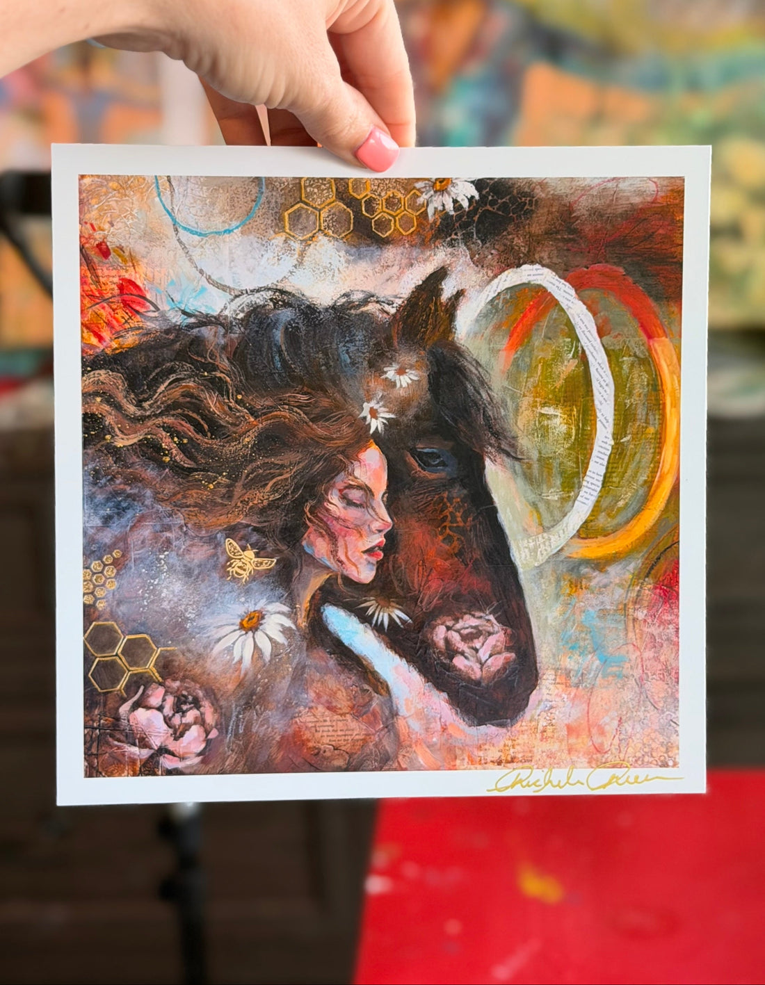 Artistic depiction of a woman with a horse's head, held by a hand against a blurred background.