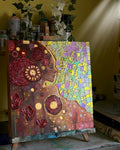 Colorful mosaic art piece on an easel with various materials in the background.